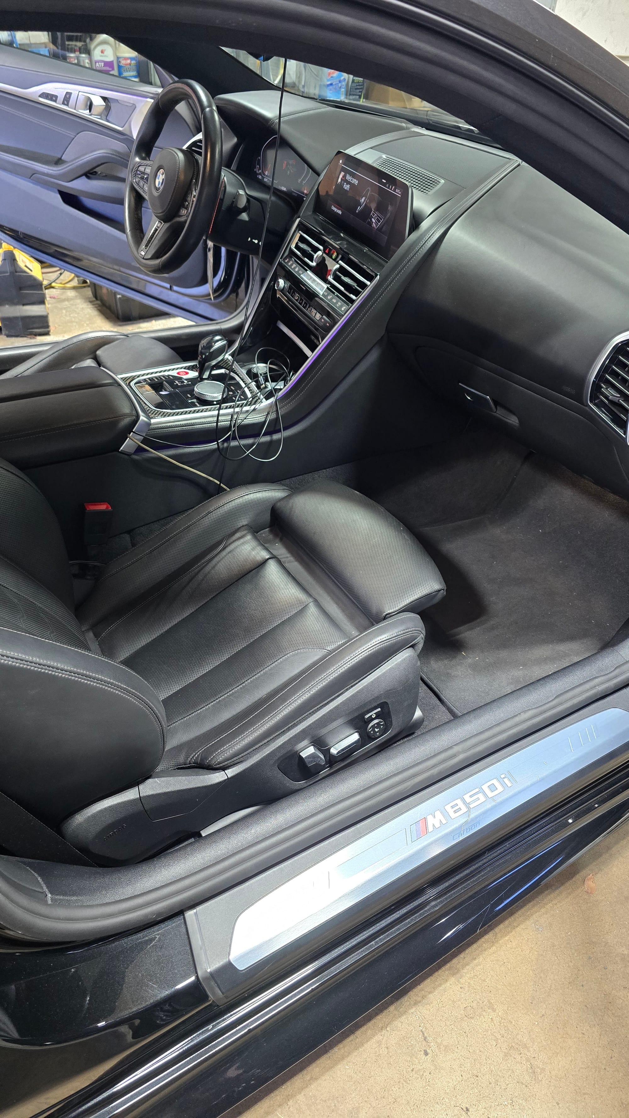 Clean black leather passenger seat and dash in a BMW M850i