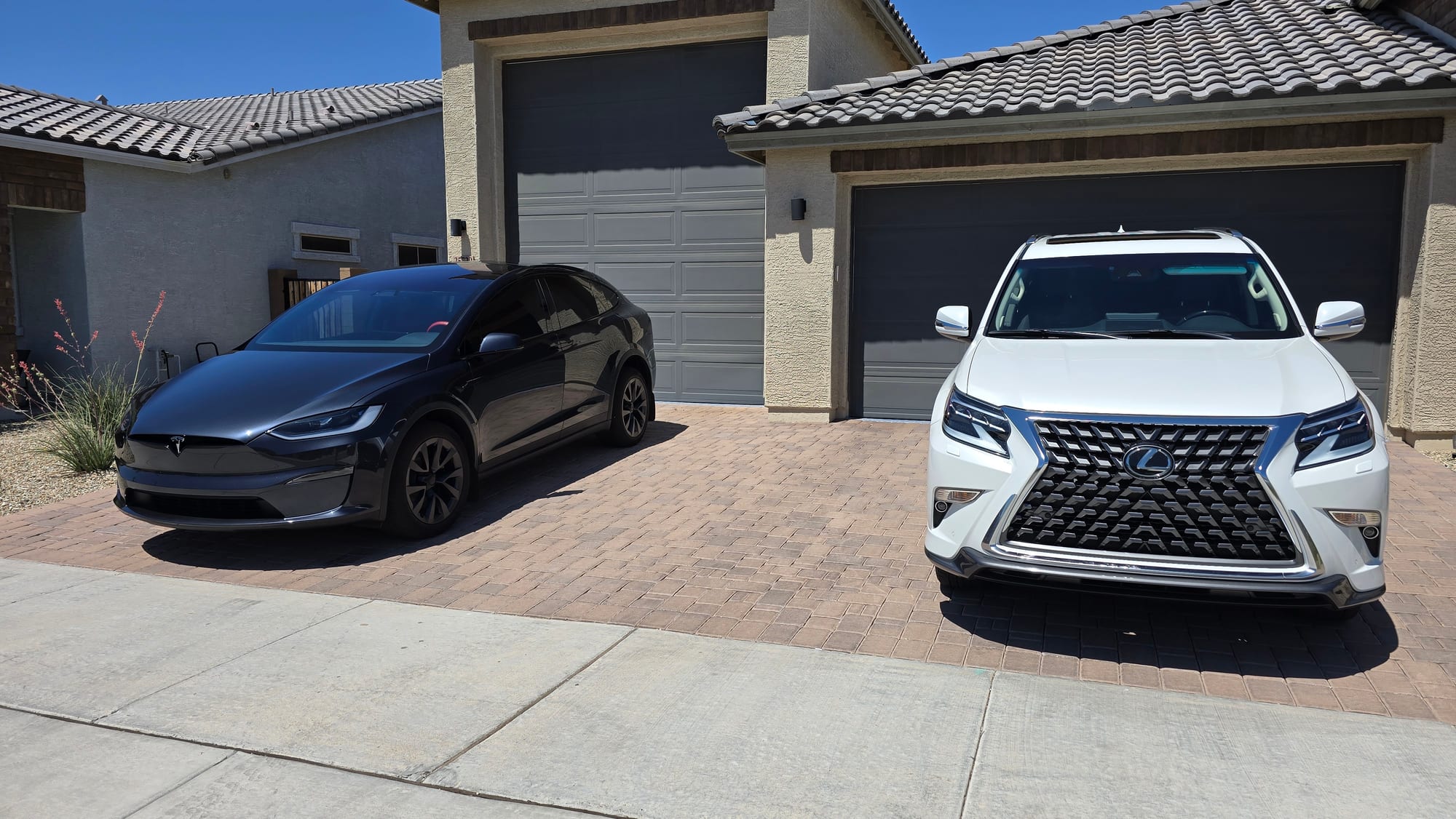 Two clean vehicles parked in an Arizona paver driveway after a mobile detailing visit in Glendale, AZ